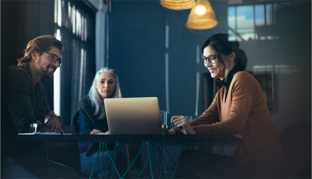 people collaborating at table with laptop